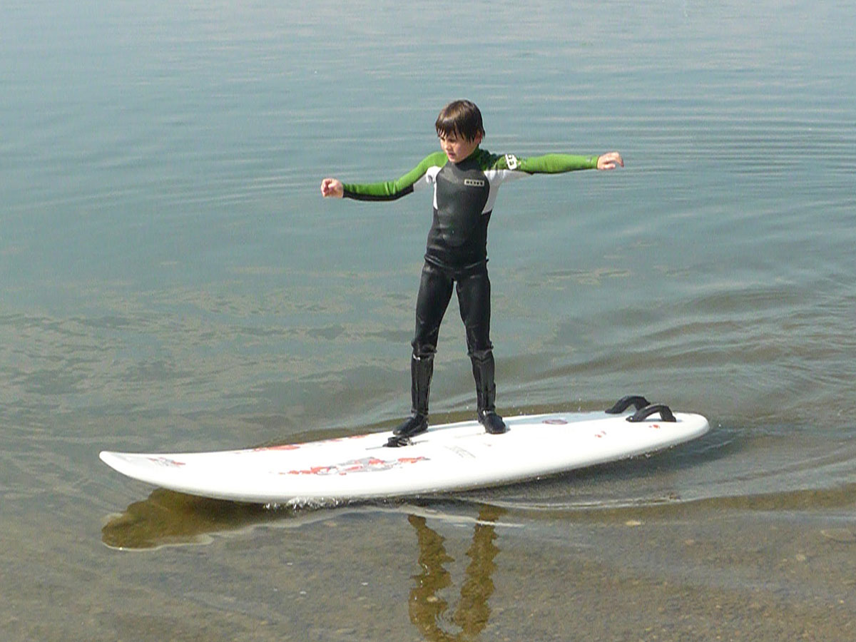 Bernau Chiemsee junger Surfer in Neoprenanzug